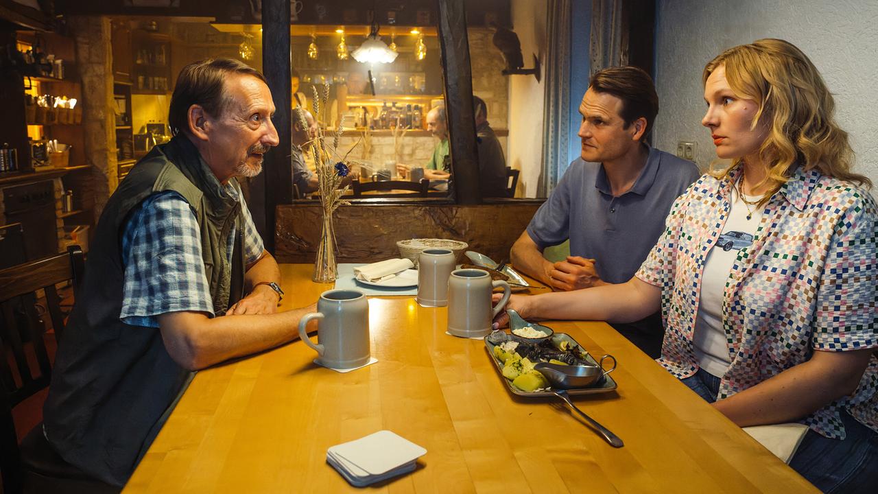 Rödel, Kriminalhauptkommissar Felix Voss und Kriminalhauptkommissarin Emmy Rathgeber sitzen im Gasthof Martin in Gottesgarten an einem Tisch und führen ein Gespräch.