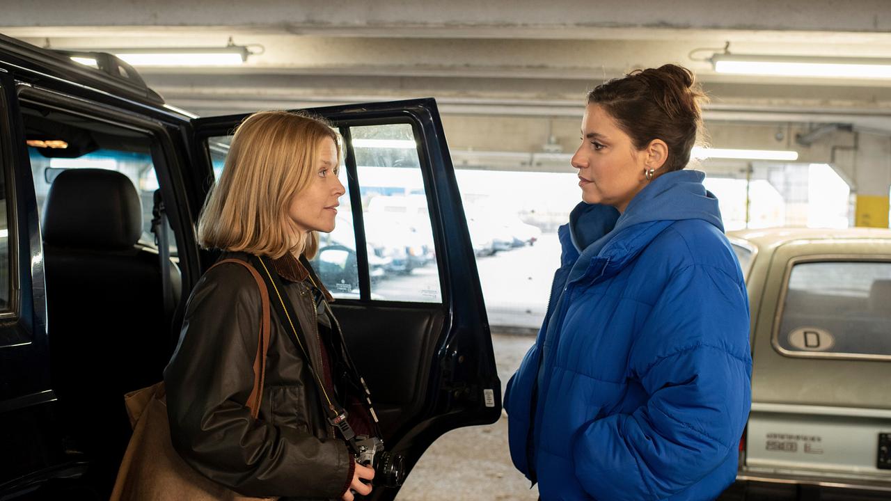 Haben ihre Bewährungsprobe überstanden: Elli und Mila sprechen miteinander neben einem offenen Geländewagen in einer Tiefgarage.