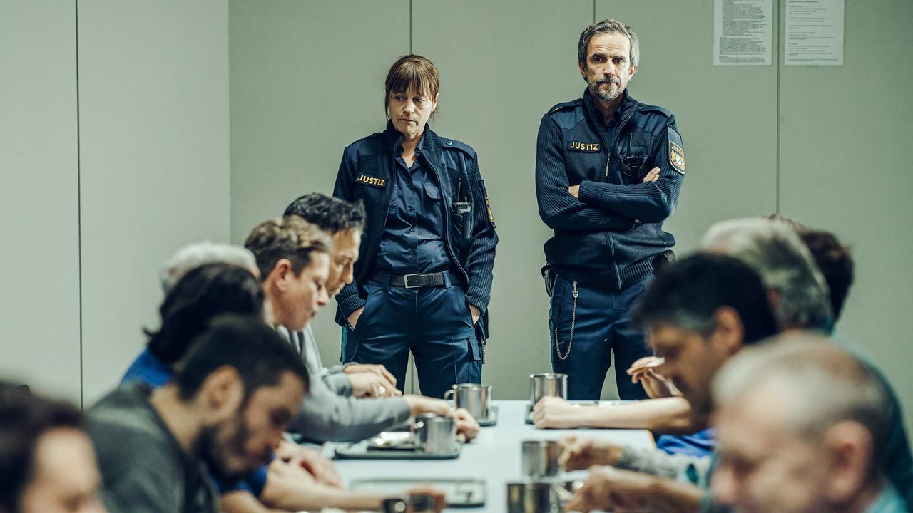 "Tatort - Das Wunderkind": JVA Beamtin Anja Bremmer (Jule Ronstedt) und JVA Beamter Stefan Claussen (Felix Hellmann) beobachten die Unruhe im Speisesaal argwöhnisch.