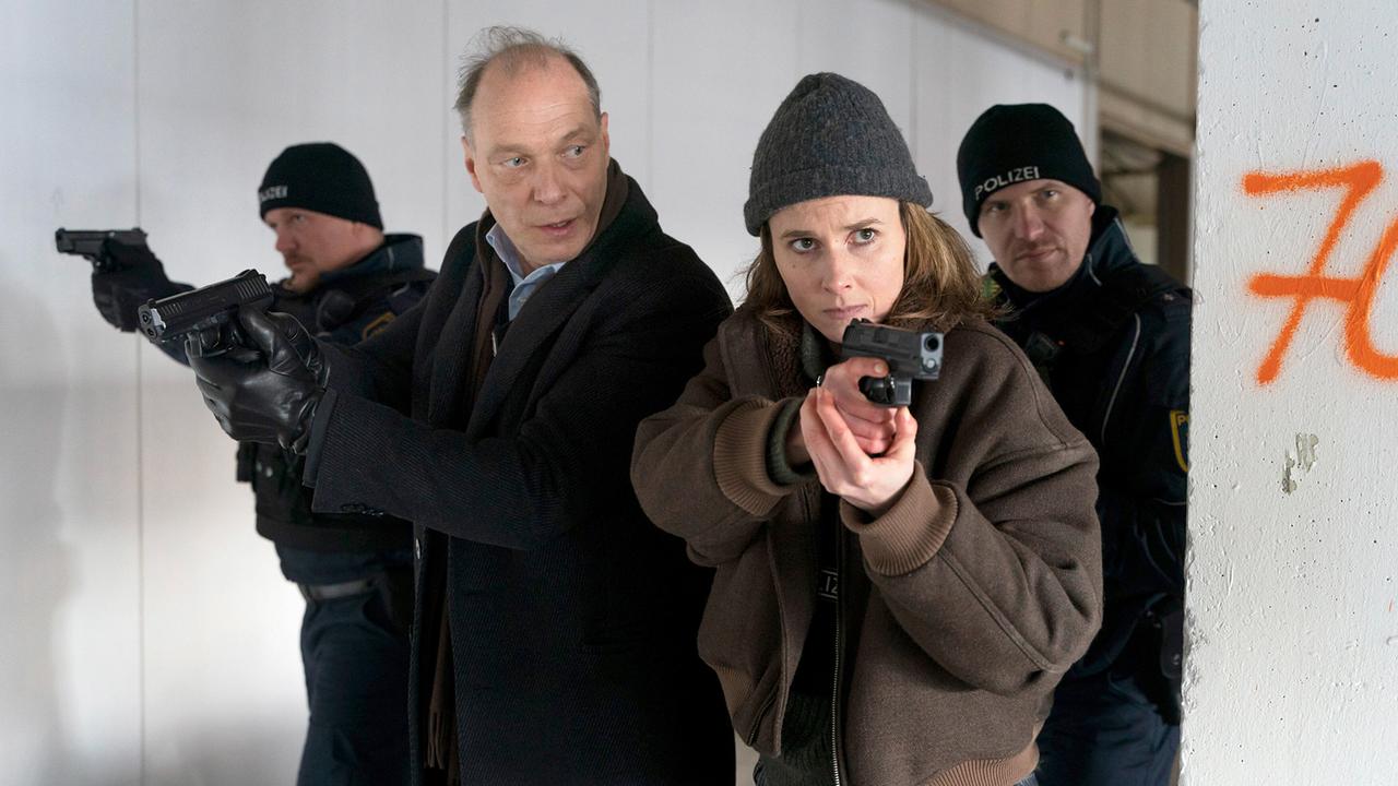 "Tatort: Unter Feuer": Peter Schnabel (Martin Brambach), Karin Gorniak (Karin Hanczewski) und Polizisten stürmen die Werkstatt von Marek Krug, da sie Schüsse gehört haben. 