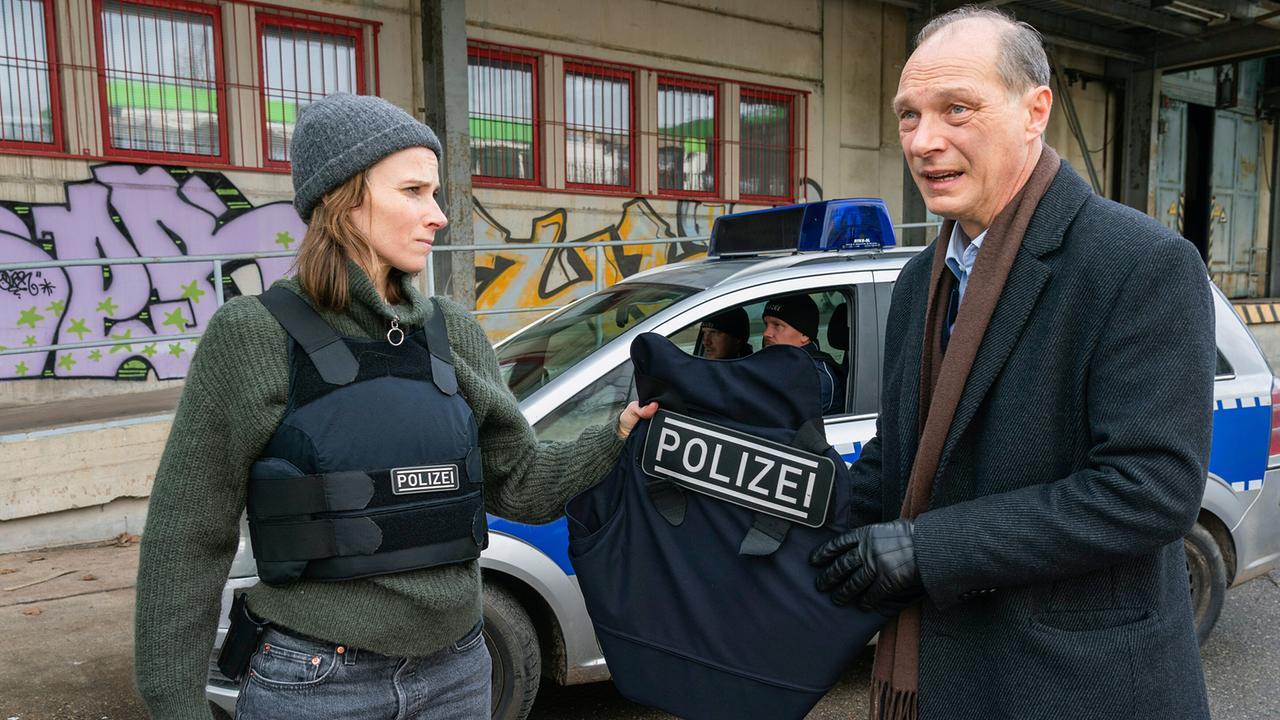 "Tatort: Unter Feuer": Karin Gorniak (Karin Hanczewski) und Peter Schnabel (Martin Brambach) mit Schusswesten bei einem Einsatz. Auf dem Fabrikgelände von Marek Krug fallen Schüsse.