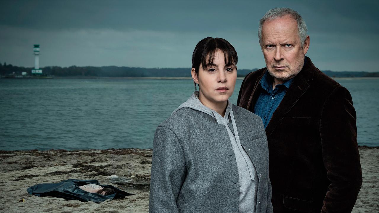 "Tatort: Borowski und das ewige Meer": Die Kieler Polizei findet die Leiche der 19-jährigen Clara Weidenfeld am Strand. Die Indizien deuten auf eine Beziehungstat hin und führen schnell zu Claras eifersüchtigem Freund Benno, der im Verhör mit Borowski (Axel Milberg, re.) und Sahin (Almila Bagriacik) die Streitigkeiten mit seiner Freundin zugibt, das Tötungsdelikt aber abstreitet.