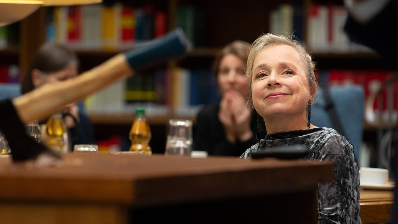 "Tatort: Man stirbt nur zweimal": Silke „Albrecht“ Haller (ChrisTine Urspruch) amüsiert sich über Dr. Boernes eindringliche Darstellung der Betrugsmaschen und seine dramatische Demonstration beim Seminar über Versicherungsbetrug.