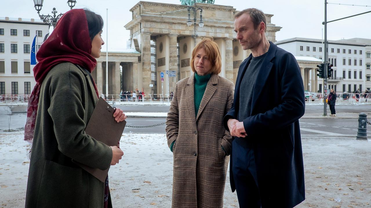 "Tatort: Vier Leben": Susanne Bonard (Corinna Harfouch, mi.) und Robert Karow (Mark Waschke, re.) finden die Verdächtige Soraya Barakzay (Pegah Ferydoni, li.) bei einer Protestaktion vor dem Brandenburger Tor.