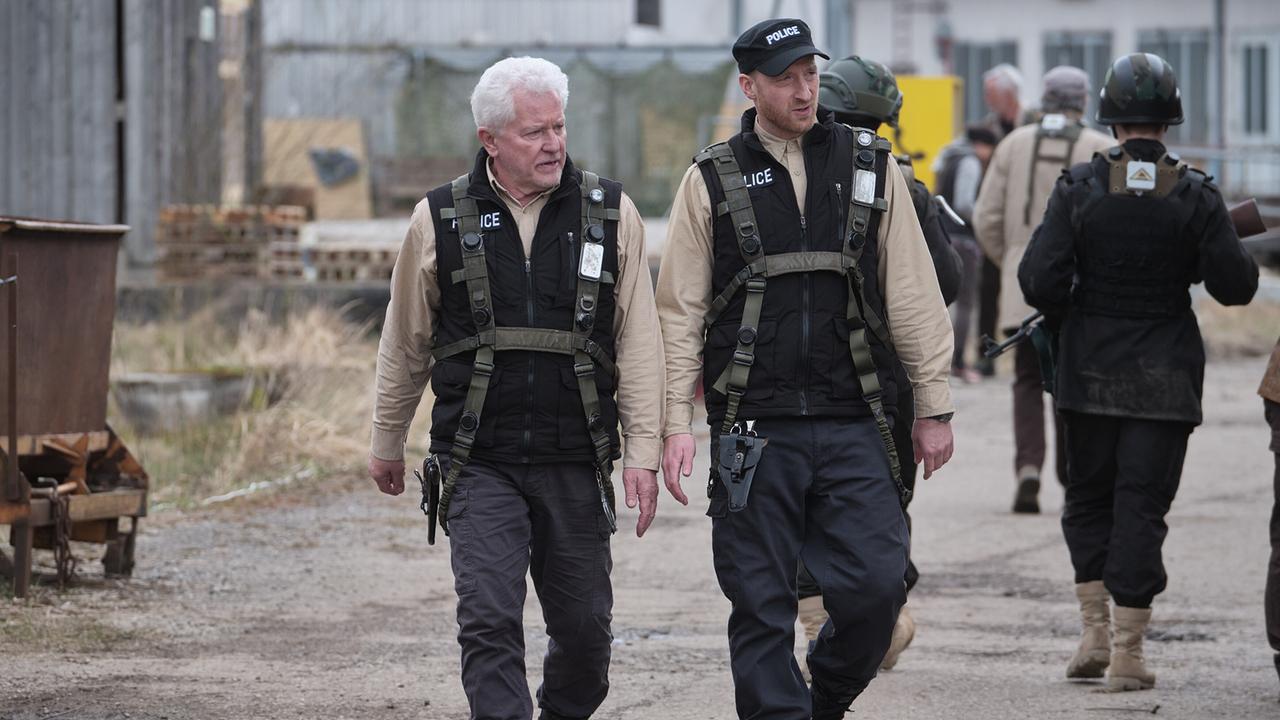 "Tatort: Charlie": Hauptkommissar Ivo Batic (Miroslav Nemec) und Maximlian Frei (Lukas Turtur) überqueren gemeinsam den Hauptplatz von Übungsheim und gehen Streife.