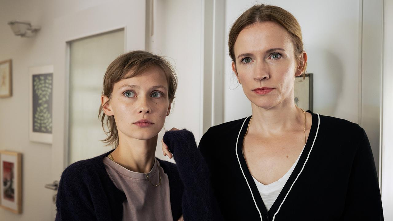 "Tatort: Fiderallala": Solveig Menke (Adina Vetter, r.) springt ihrer Tochter Fraya (Meira Durand, l.) beschützend zur Seite als Kommissar Frank Thiel und Prof. Karl-Friedrich Boerne die junge Frau zum Mord an Chris Haffmeister befragen.