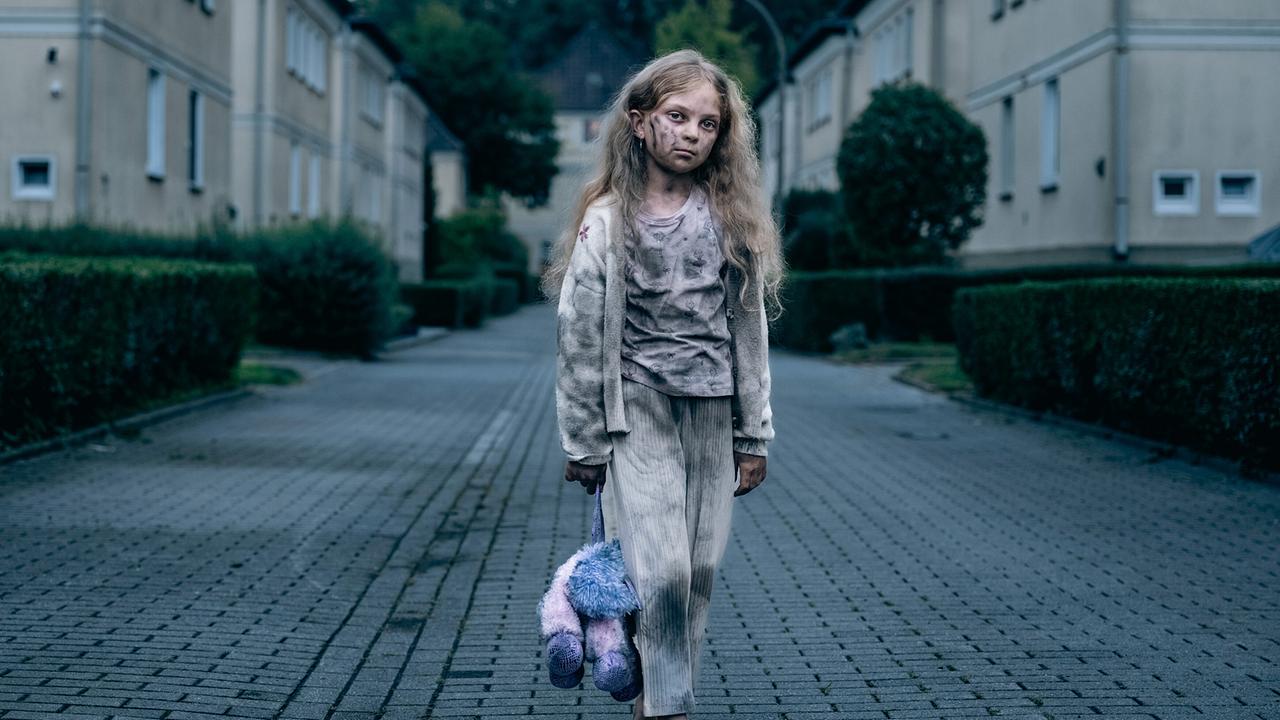 "Tatort: Feuer": Die kleine Mia (Tesla Tekin) läuft mit rußgeschwärztem Gesicht durch eine Siedlung am Rand von Dortmund.