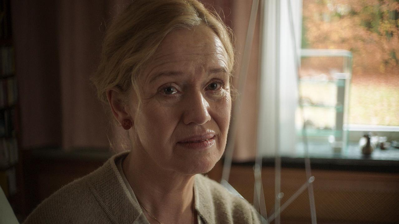 "Tatort: Ich sehe dich": Erika Schönfeld (Marion Reuter) sitzt auf der Sofakante und wird von Kommissar Felix Voss befragt.