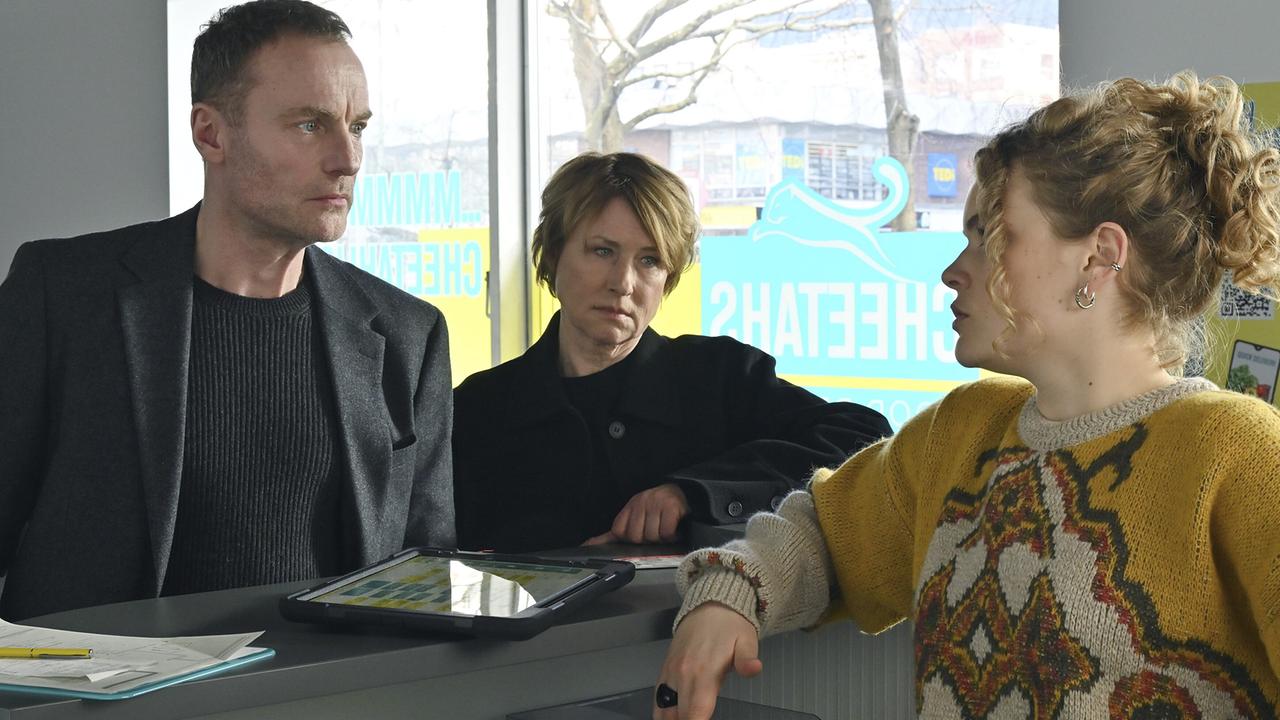 "Tatort: Erika Mustermann": Susanne Bonard (Corinna Harfouch, mitte) Robert Karow (Mark Waschke, li) suchen den Lieferdienst auf, für den der Tote als Fahrradkurier gearbeitet hat und treffen als erstes auf Mitarbeiterin Inke Traut (Leonie Krieg, re).