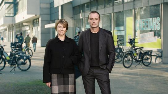 Susanne Bonard und Robert Karow stehen vor einem Berliner Fahrradlieferdienst