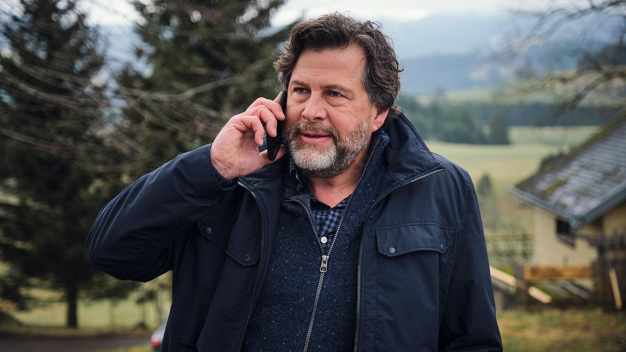 Hans-Jochen Wagner am Handy in ländlicher Umgebung