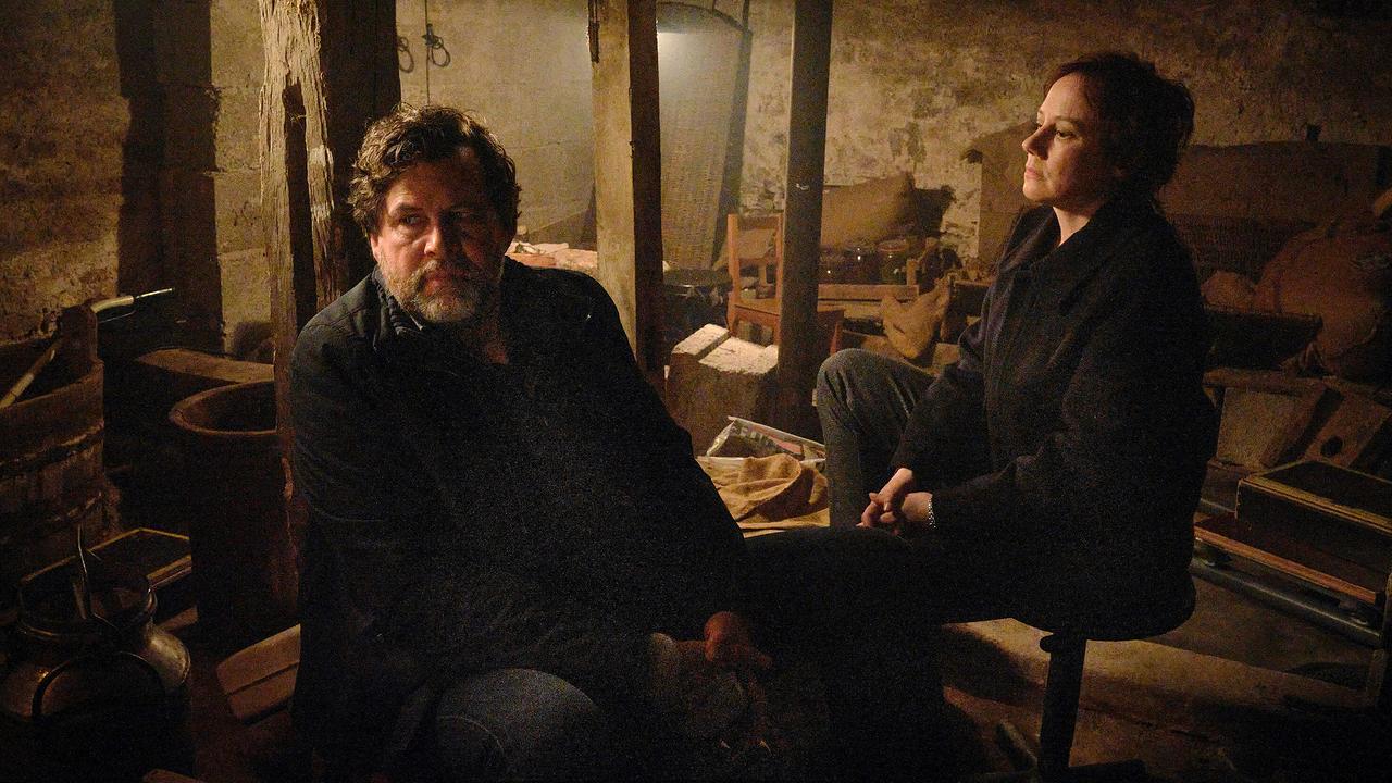 Hans-Jochen Wagner und Franziska Tobler siten in einem dunklen, rustikalen Kellerraum.