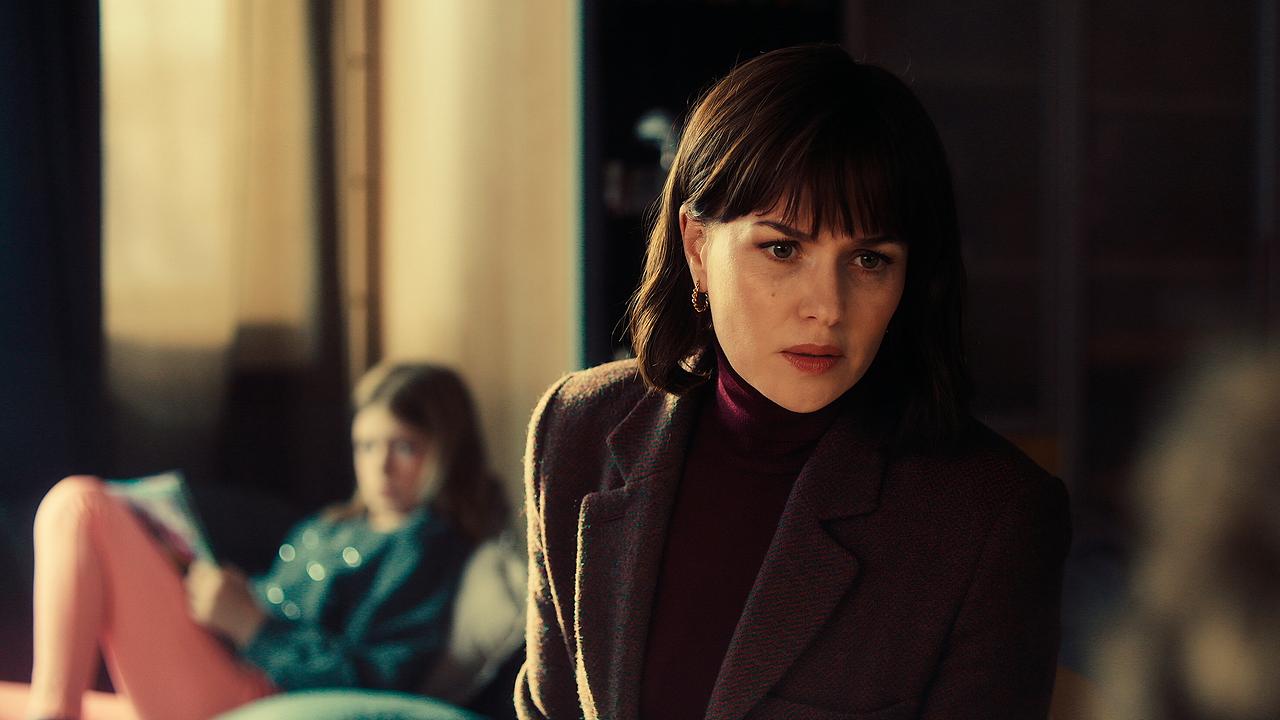 © ORF/HR/Sommerhaus Melika Foroutan im Vordergrund blickt auf etwas, im Hintergrund liegt ein Kind auf einem Sofa.