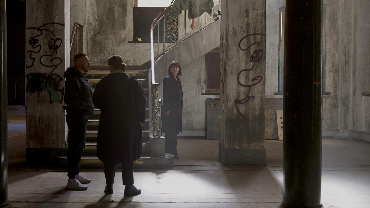 © ORF/HR/Sommerhaus/Daniel Dornhöfer Edin Hasanovic, Petra Hartung und Melika Foroutan stehen in einem heruntergekommenen Gebäude mit Graffiti, eine weitere Person beugt sich über ein Treppengeländer.