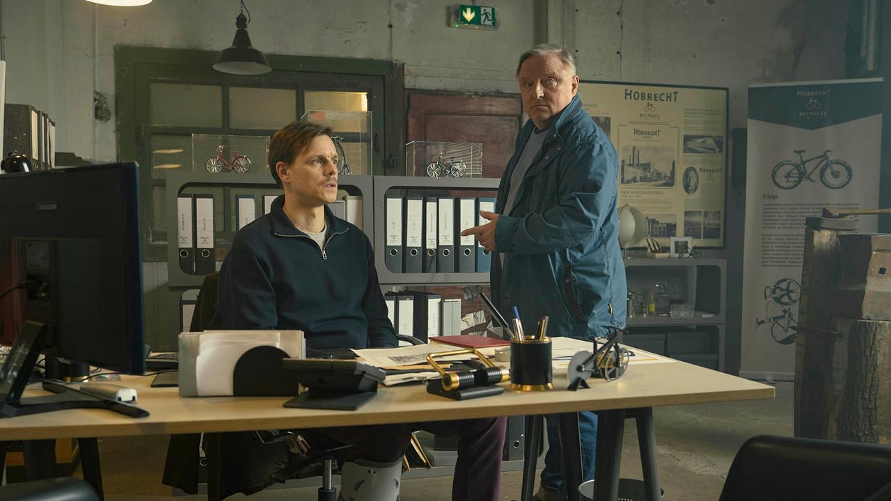 Kommissar Thiel hat noch Fragen an den Juniorchef Konstantin Hobrecht in einem Büro mit Aktenordnern.