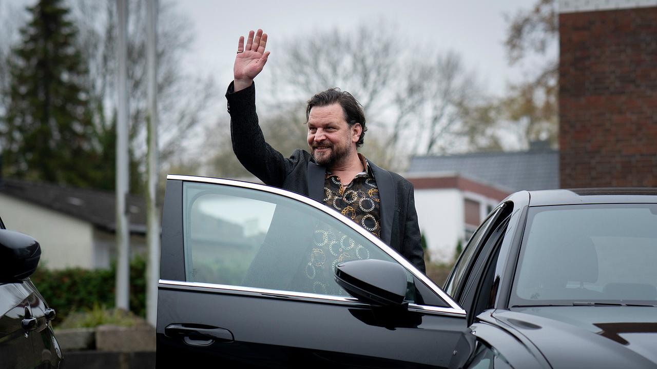 Örtlicher Drogenhändler und Platzhirsch Ervin Zoric steigt aus einem schwarzen Auto und hebt zur Begrüßung die Hand.