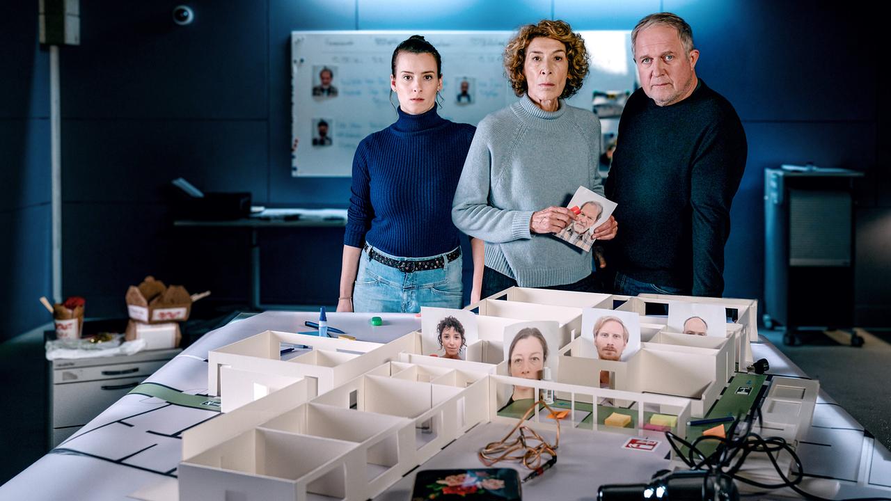 Meret Schande, Bibi Fellner und Moritz Eisner  stehen in einem Raum vor einem Tisch mit einem detaillierten Architekturmodell des Pflegeheims.