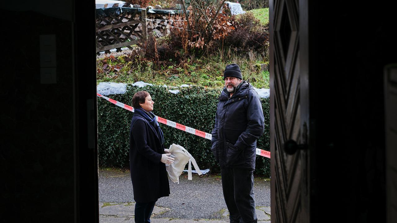 Franziska Tobler und Friedemann Berg sprechen vor einem mit Absperrband markierten Bereich vor einem Haus.