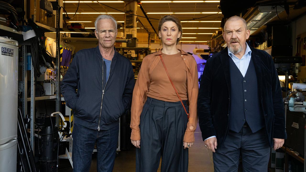 Max Ballauf, Oberspielleiterin Jenny Ibsen und Freddy Schenk stehen gemeinsam in einem Werkraum der Interimsspielstätte und blicken nach vorne.