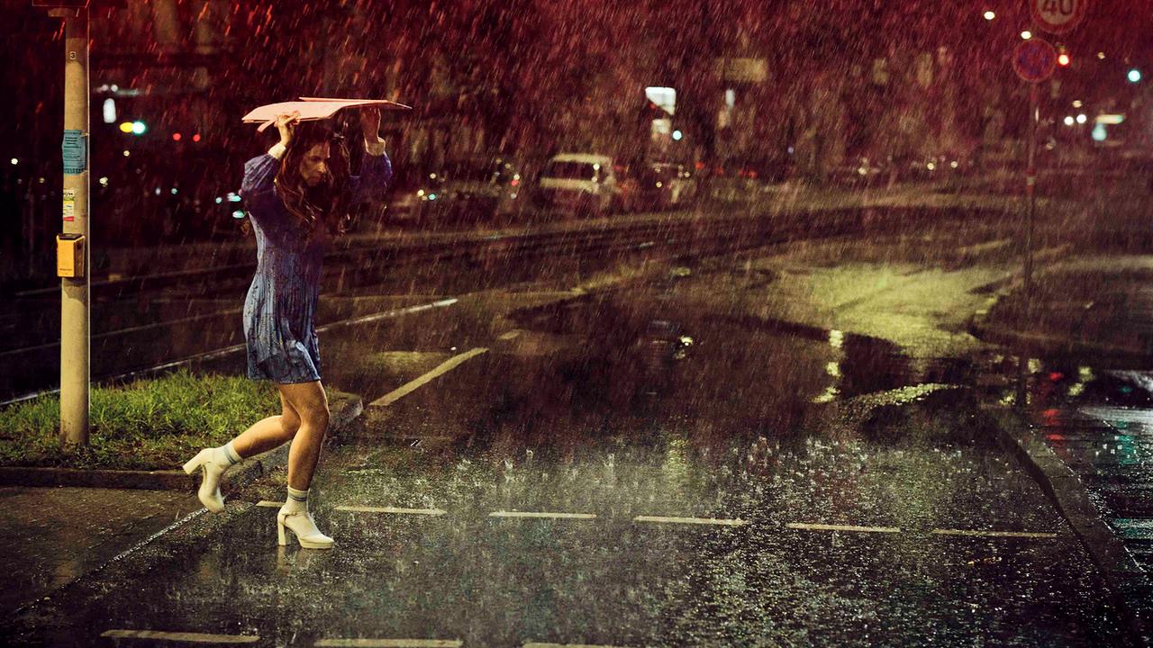 Pony Hübner läuft verstört über eine Straße in einer regnerischen Nacht.