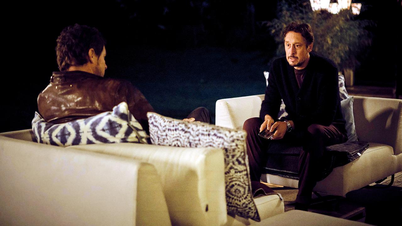 Stephan Hübner und Sebastian Bootz sitzen spätabends im Freien auf Sofas und führen ein Gespräch.