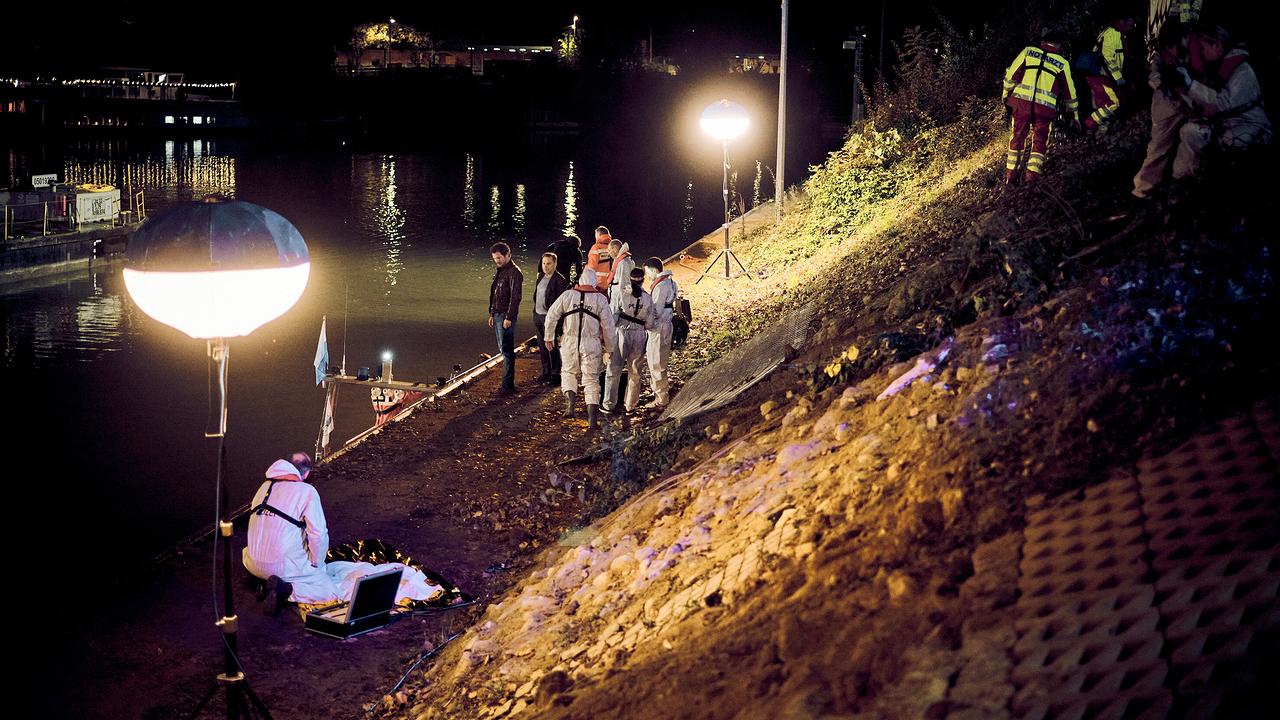 Die Kommissare Sebastian Bootz und Thorsten Lannert stehen nachts am Neckarufer, wo der Wagen mit dem toten Kind geborgen und die Untersuchung aufgenommen wird.