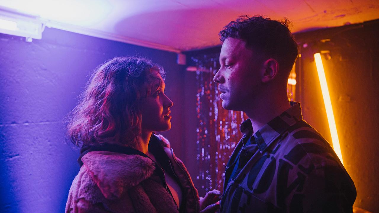 Sie treffen sich im Hinterzimmer seines Clubs: Betty Höpken und Mike Hanisch stehen in einem mit Neonröhren bunt beleuchteten Raum.