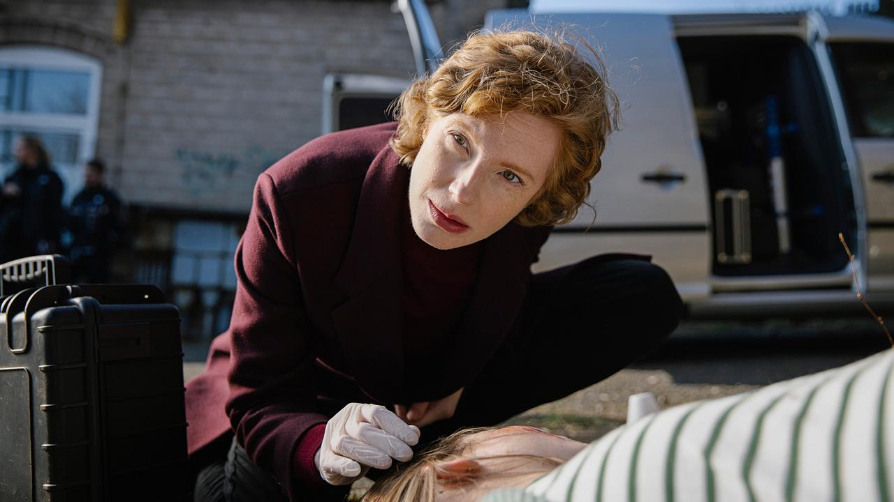 Kommissarin Linda Selb sieht sich die Leiche am Tatort genauer an.