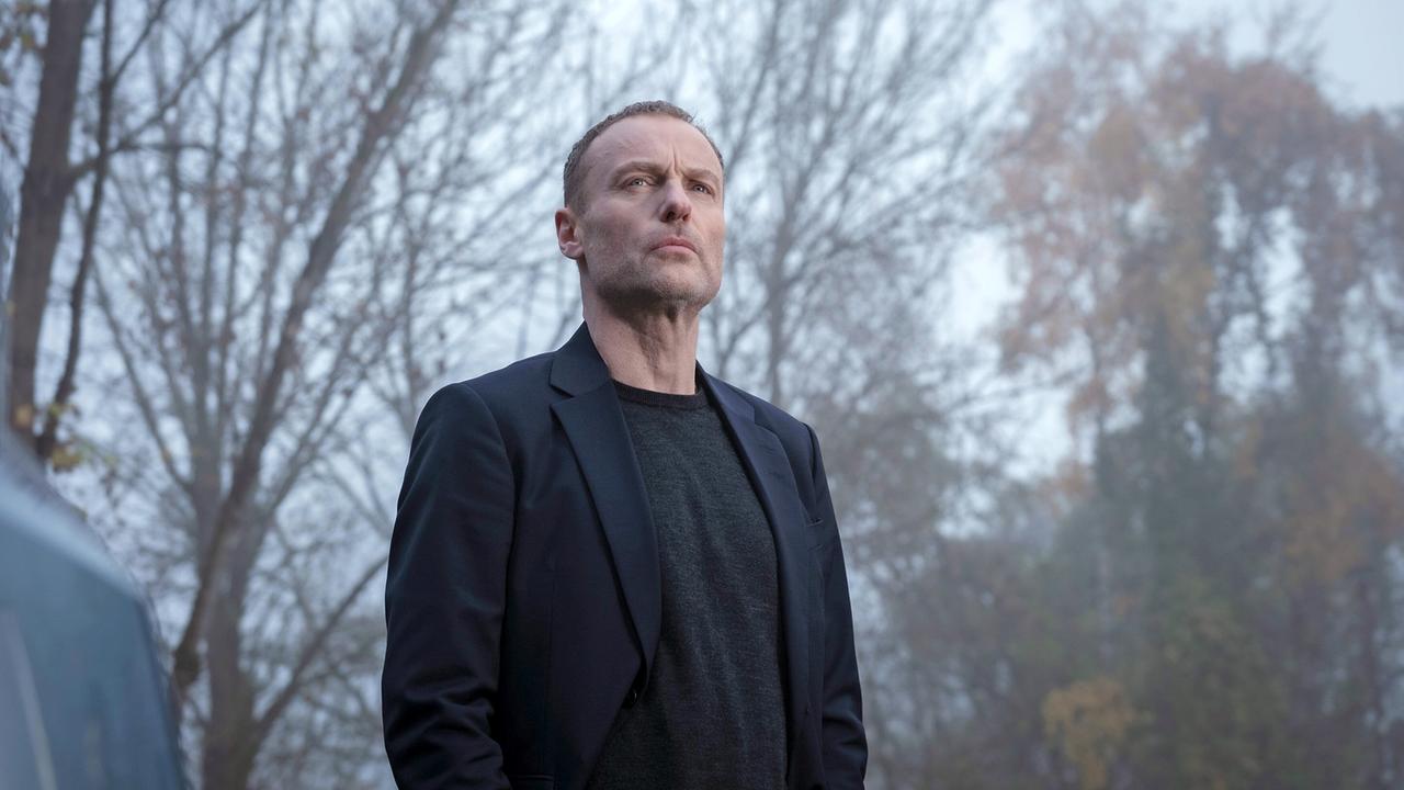 Robert Karow sieht sich bei nebeligem Wetter in der Nähe des Tatorts an der ehemaligen Abhörstation auf dem Berliner Teufelsberg um.