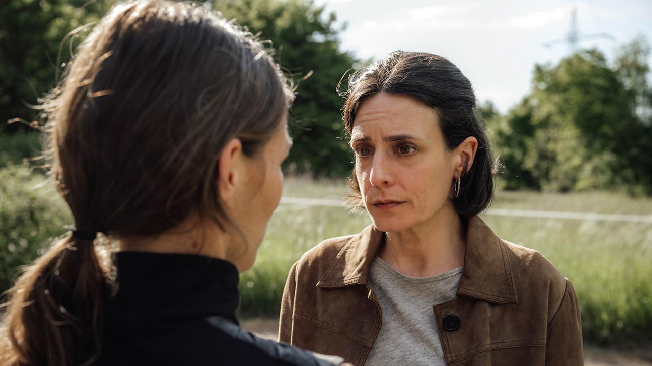Katja Scherf und Esther Baumann sprechen draußen in einer grünen Umgebung über die Vergangenheit und die Zeit seither.