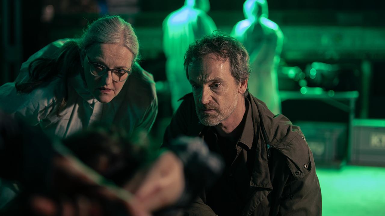 Gerichtsmedizinerin Greta Leitner und Peter Faber begutachten die Leiche des vermutlich totgeprügelten Klaas Martens an einem grün-beleuchteten Tatort.