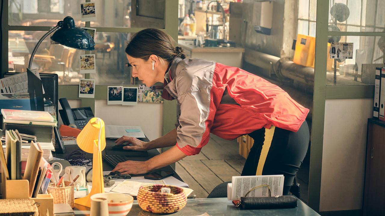 In einem ruhigen Augenblick versucht Johanna in der Velopunks-Zentrale gebeugt über einen Schreibtisch über einen Laptop Daten abzugreifen.