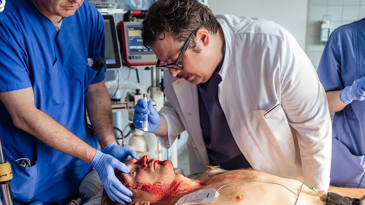"Tatort: Die Kälte der Erde": Dr. Friedemann Lech (Till Butterbach) versucht, das Leben des schwer verletzten Andreas Schneider (Nils Bannert) zu retten.