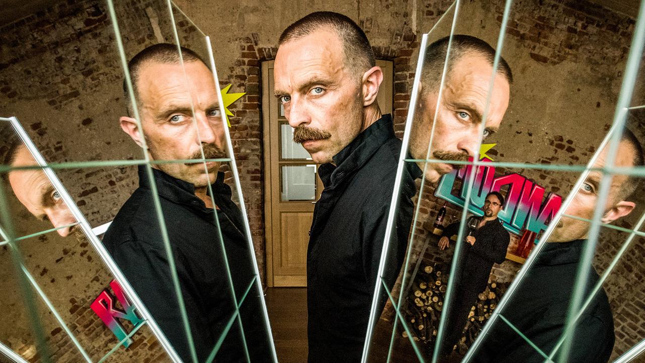 "Tatort: Gott ist auch nur ein Mensch": Vielschichtige Persönlichkeit: Aktionskünstler Zoltan Rajinovic alias G.O.D. (Aleksandar Jovanovic) wird verehrt, auch von Prof. Karl-Friedrich Boerne (Jan Josef Liefers, rechts im Hintergrund).