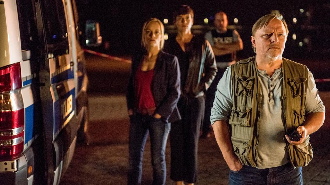 "Tatort: Gott ist auch nur ein Mensch": Kurz vor der Eröffnung der „Internationalen Skulptur-Tage“ taucht am Münsteraner Aasee ein unbekanntes Kunstwerk auf. Die Kommissare Nadeshda Krusenstern (Friederike Kempter, links) und Frank Thiel (Axel Prahl, rechts) haben den Verdacht, dass es mit einer Straftat in Verbindung stehen könnte. Die Kuratorin des international anerkannten Kunstereignisses, Klara Wenger (Victoria Mayer, 2.v.l.), beobachtet den Polizeieinsatz.