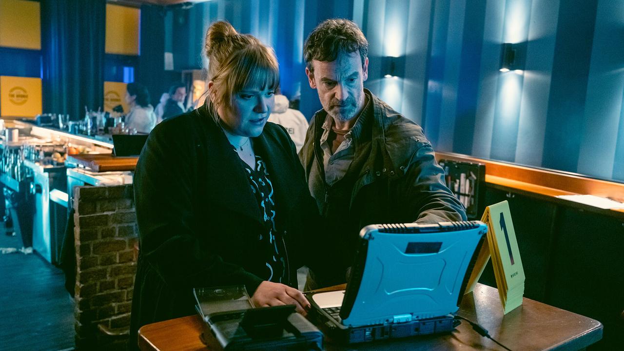 "Tatort: Love is pain": Rosa Herzog (Stefanie Reinsperger) und Peter Faber (Jörg Hartmann) am zweiten Tatort, in der Bar "The Bronx" - auch hier können sie anhand der Aufnahmen der Überwachungskamera wieder genau den Tathergang nachvollziehen.