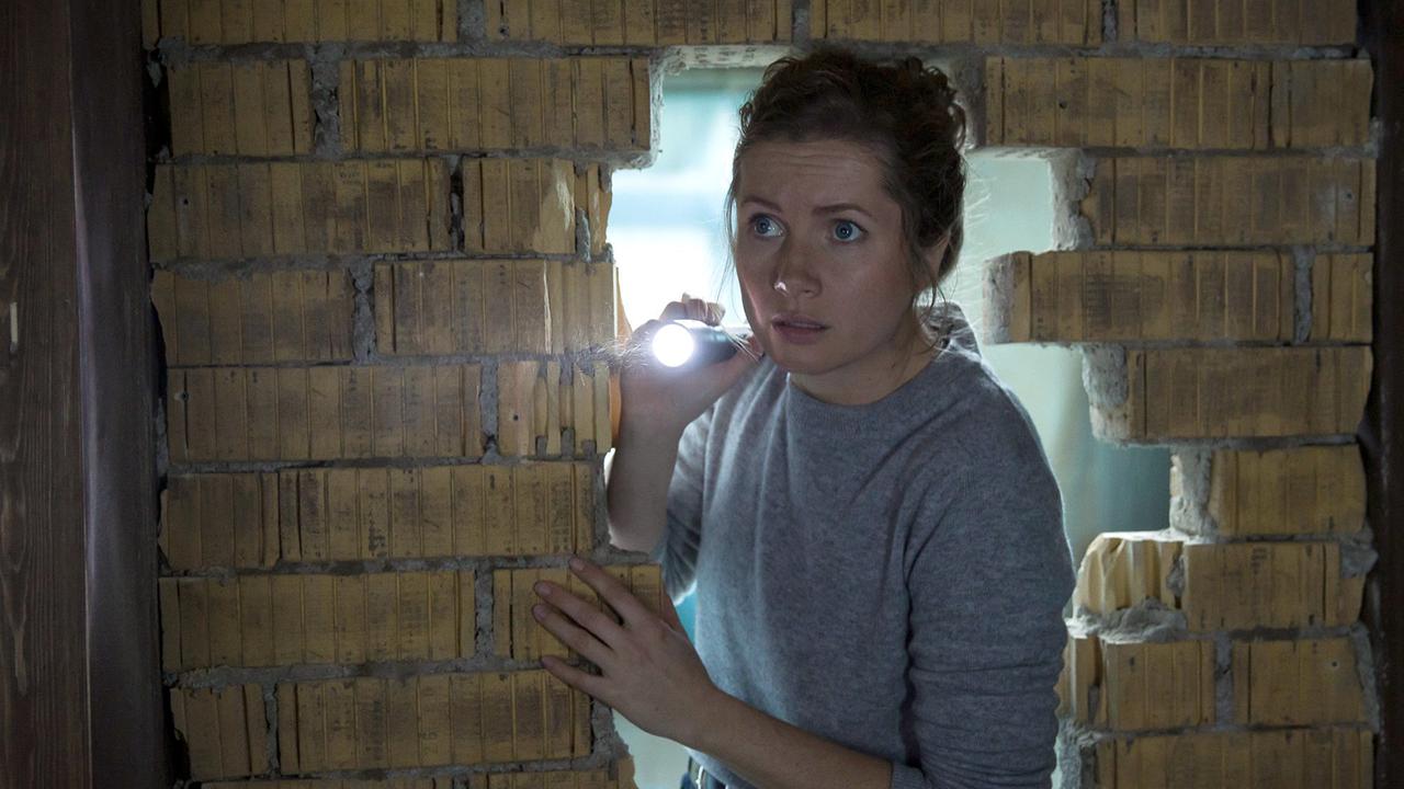 "Tatort: Parasomnia": Leonie Winkler (Cornelia Gröschel) leuchtet mit einer Taschenlampe in den dunklen Raum hinter der Mauer.