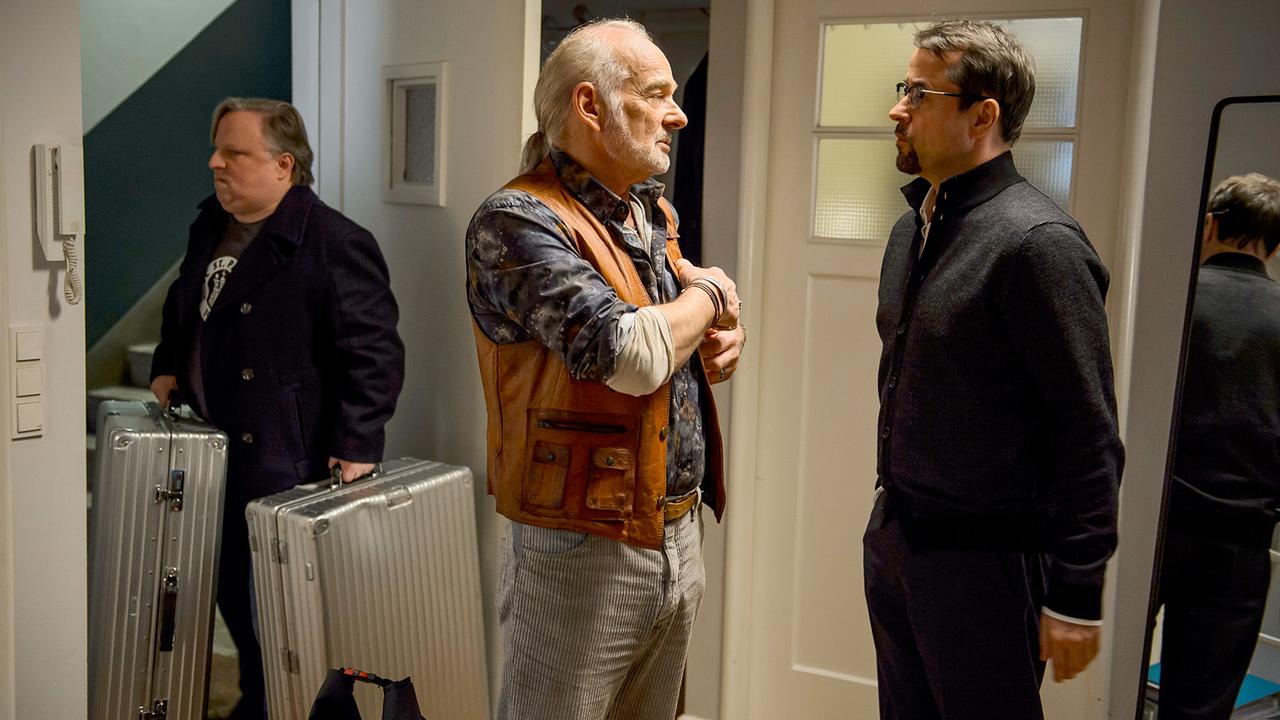 "Tatort: Schwanensee": "Vadder" Thiel (Claus D. Clausnitzer, M) begleitet Professor Boerne (Jan Josef Liefers, r.) in dessen Wohnung. Frank Thiel (Axel Prahl) trägt die Koffer des Professors.