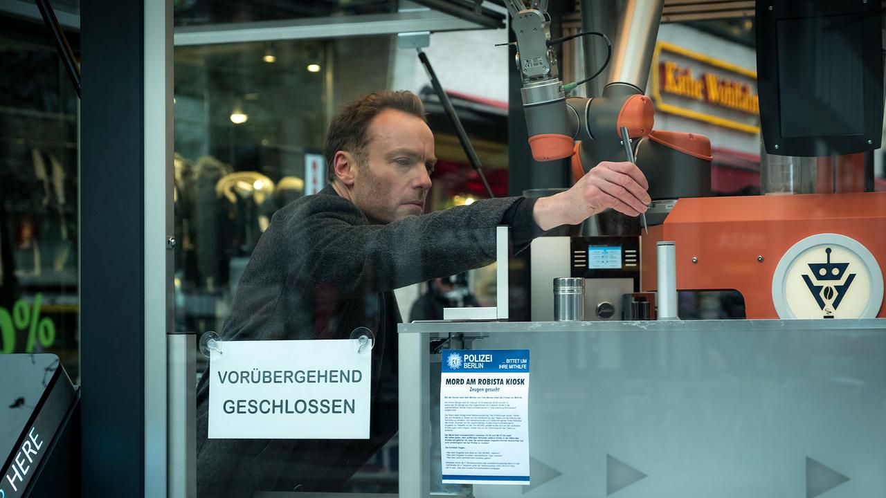 "Tatort: Tiere der Großstadt": Karow (Mark Waschke) untersucht den Roboter im Cofeeshop „Robista“.
