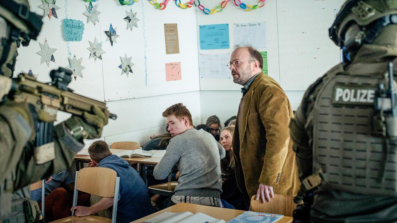 "Tatort: Unklare Lage": Der Lehrer Herr Unger (Nikolaus Frei, Mitte) versteckt sich mit seinen Schülern (Komparsen) im Klassenzimmer, als das SEK die Schule sichert und kontrolliert, ob alle in Sicherheit sind.