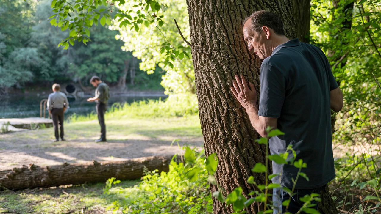 "Tatort: Vergebung": Daniel Vogt (Jürgen Hartmann) hat den Ermittlern Thorsten Lannert (Richy Müller) und Sebastian Bootz (Felix Klare) nicht verraten, dass er das Opfer persönlich kannte. Und möchte von ihnen auch nicht am Fluss gesehen werden.