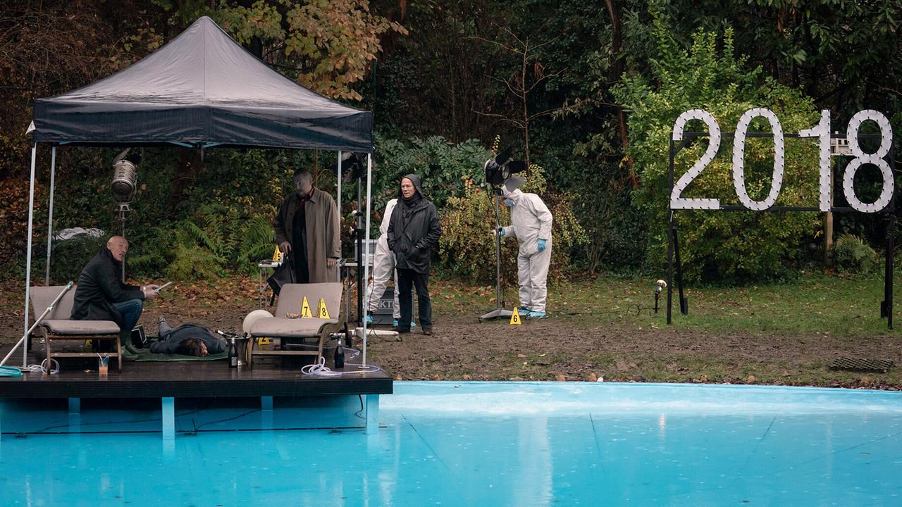 "Tatort: Vier Jahre": Nach einer Silvesterparty im Haus des Schauspieler-Ehepaares Seitz wird am Neujahrsmorgen auf dem Grundstück ein Toter gefunden. Rechtsmediziner Dr. Roth (Joe Bausch, l) untersucht den Leichnam und gibt den Kommissaren Freddy Schenk (Dietmar Bär, mi.) und Max Ballauf (Klaus J. Behrendt, r.) seine ersten Einschätzungen. KTU-Mitarbeiter untersuchen die Lampen, die als Dekoration bei der Party verwendet wurden.
