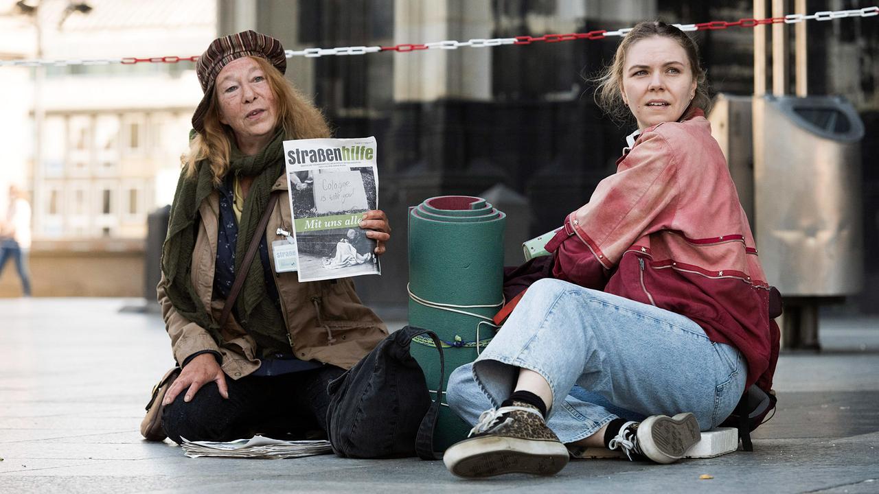 "Tatort: Wie alle anderen auch": Monika Keller (Rike Eckermann, links) verkauft am Dom Obdachlosenzeitungen. Sie hilft Ella Jung (Ricarda Seifried, rechts), die gerade erst lernt, sich auf der Straße durchzuschlagen.