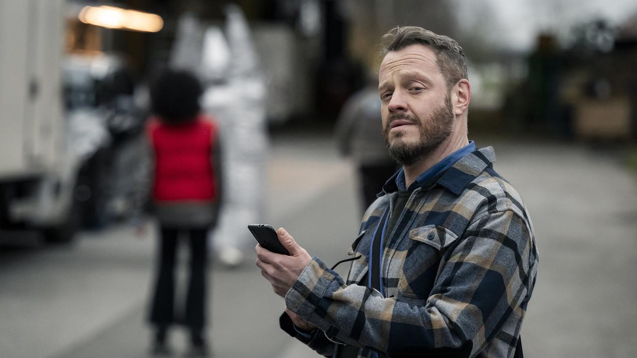 Sonderermittlungseinsatz für Kommissar Norbert Jütte: Er steht am "Sachen und Machen"-Set auf dem Studiogelände und schaut auf ein Smartphone.