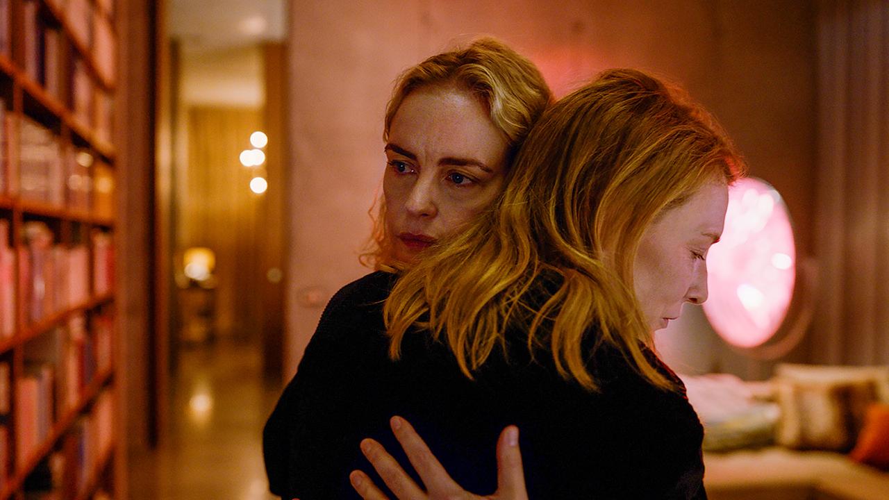 © ORF/Universal/Focus Features In einem Wohnzimmer mit Bücherregalen umarmen sich Nina Hoss als Sharon Goodnow und Cate Blanchett als Lydia Tár, mitfühlend blicken beide blicken gedankenverloren zur Seite