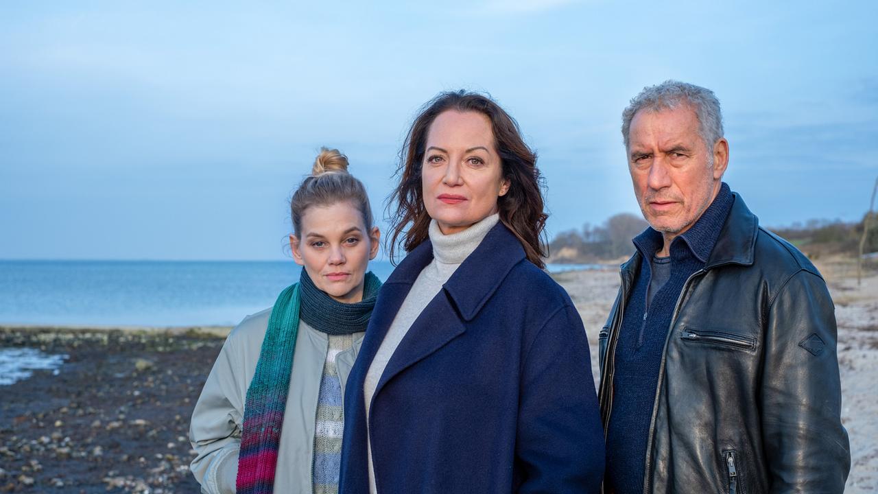 Jana Winter und ihre engsten Mitarbeiter, Alwa Sörensen und Matthias Hamm, stehen gemeinsam am Strand und blicken in die Ferne.
