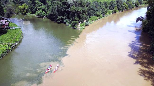 Eine Flussmündung mit zwei Kanus aus der Vogelperspektive