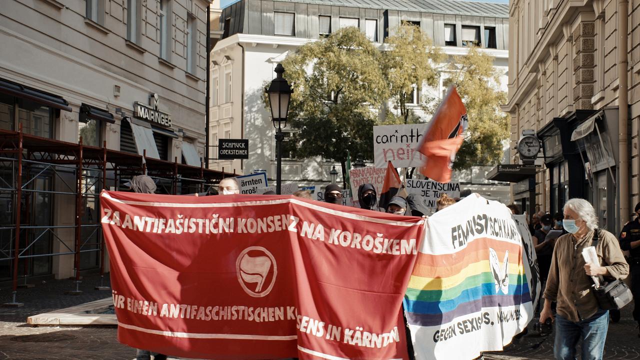 Proteste gegen das Verschwinden: Demonstrierende ziehen mit roten und bunten Bannern durch eine enge Innenstadtgasse und setzen ein politisches Zeichen.