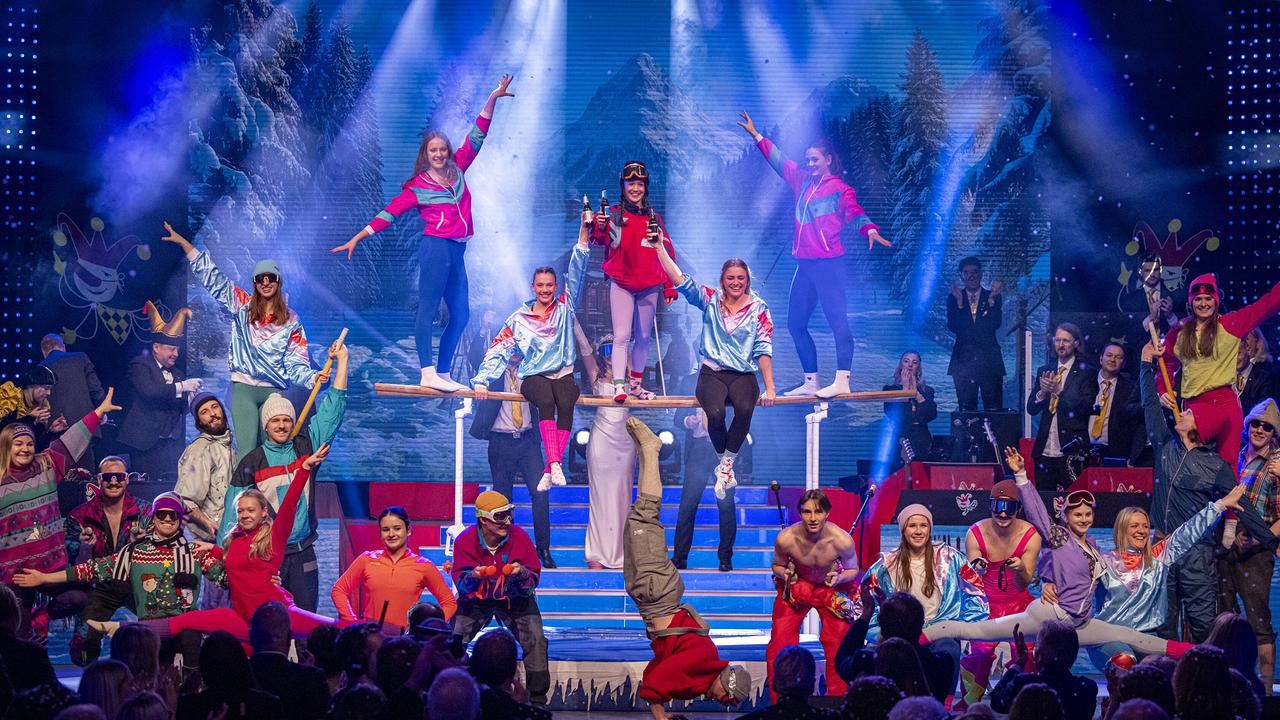 © ORF/Peter Krivograd Die Après Ski Turner in bunten Kostümen präsentiert eine akrobatische Showformation vor winterlicher Kulisse und Bühnenlicht.