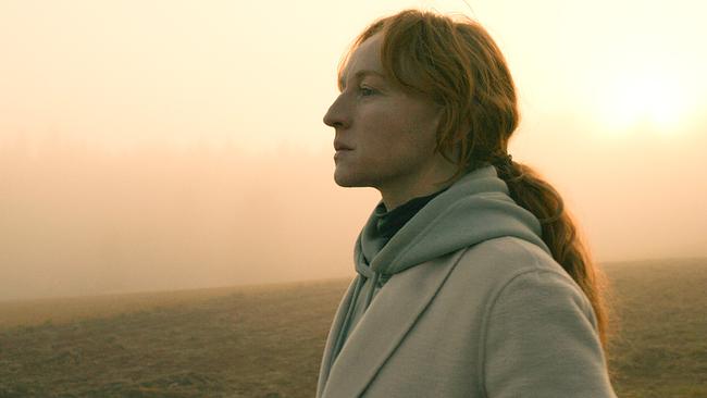 © ORF/Wega Film Marian eingehüllt in einen Mantel steht auf einem Feld in einer nebligen Landschaft, wo langsam die Sonne durchkommt, und schaut in die Ferne.